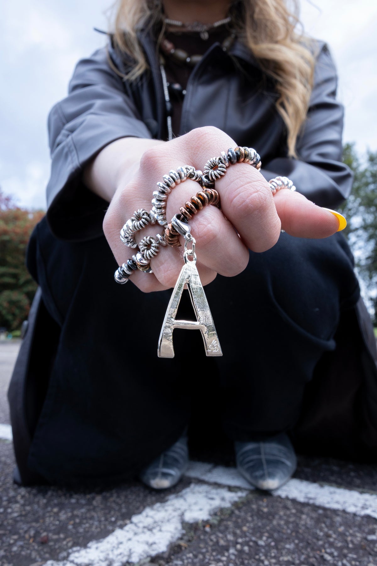 Mano con anillos Alma y collar con charm de letra A de RONNIKA